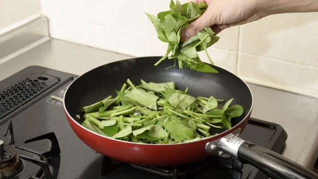 作り方3：フライパンでニンニクを炒め、空心菜の茎、葉の順に加える