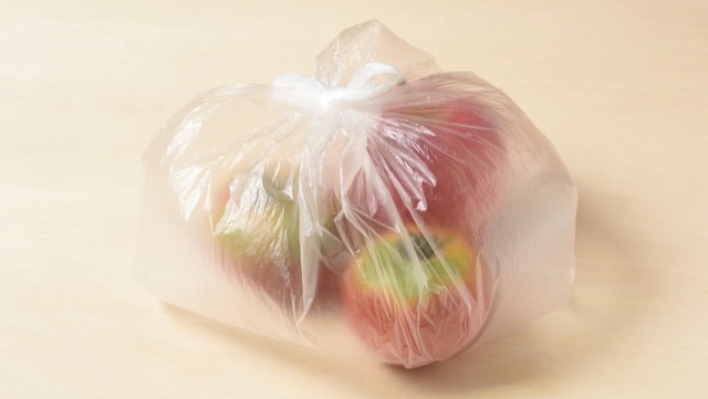 未熟なトマトとりんごを保存用ビニール袋に入れ、空気を含ませてしっかりと口を閉じる