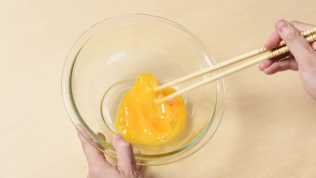 レタスチャーハンの作り方3：卵をボウルに割り、箸を底に付けてかきまぜる