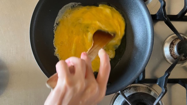 溶き卵をフライパンで炒め、炒り卵にする