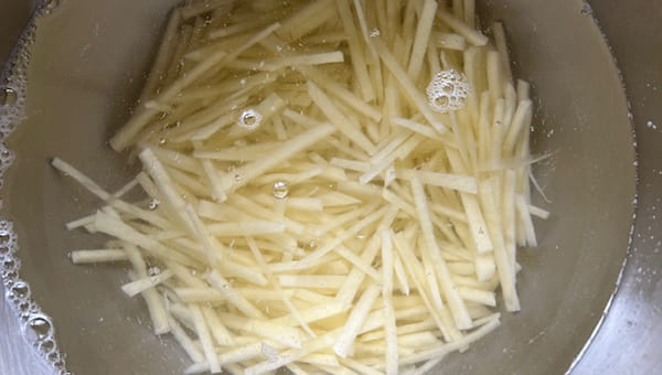千切りにしたじゃがいもを水にさらす