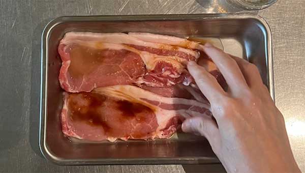 豚肉に調味料をもみ込む