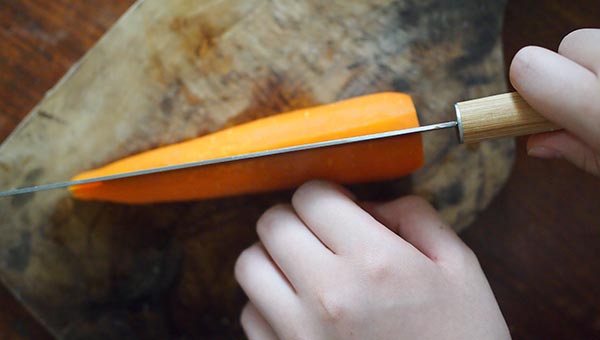 にんじんのヘタを取って縦半分に切る