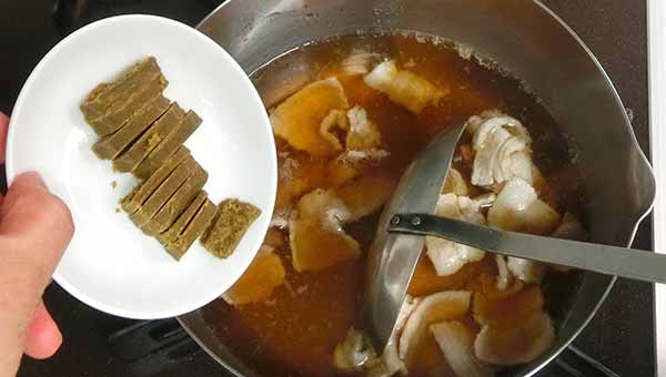 つゆに豚肉を入れて煮て、ルウを加える