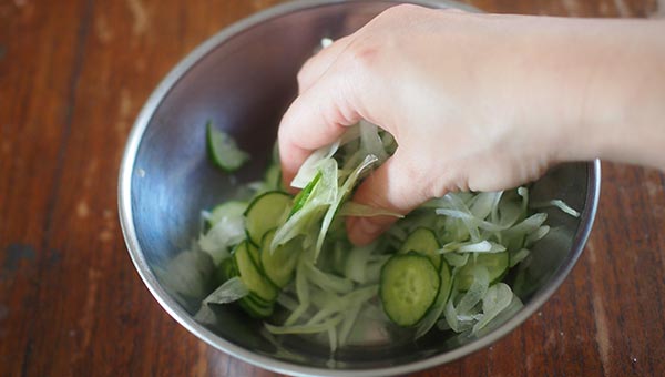 薄切りにしたきゅうりに塩をまぶして揉み、タマネギを混ぜる 薄切りにしたきゅうりに塩をまぶして揉み、タマネギを混ぜる