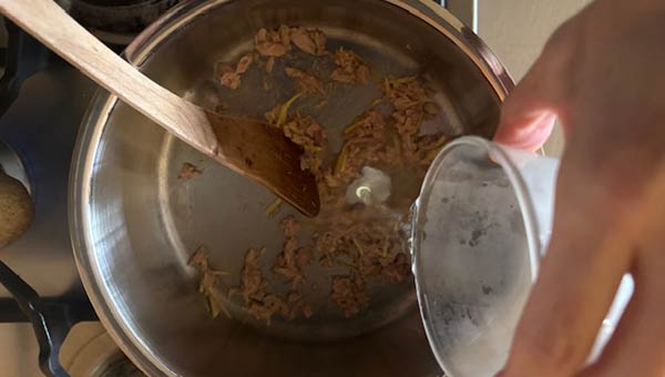 ツナを炒め、ショウガと酒を加える