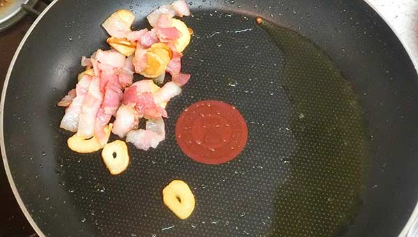 ニンニクとベーコンをオリーブオイルで炒める