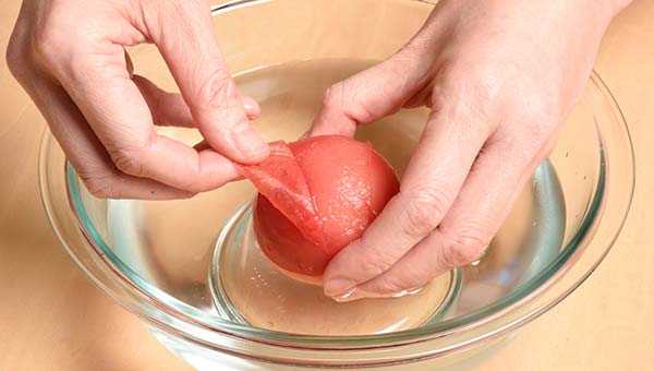 凍ったトマトを水につけると皮がめくれてくる 凍ったトマトを水につけると皮がめくれてくる