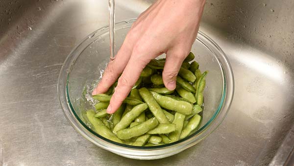枝豆を塩もみし、水で洗い流す 枝豆を塩もみし、水で洗い流す