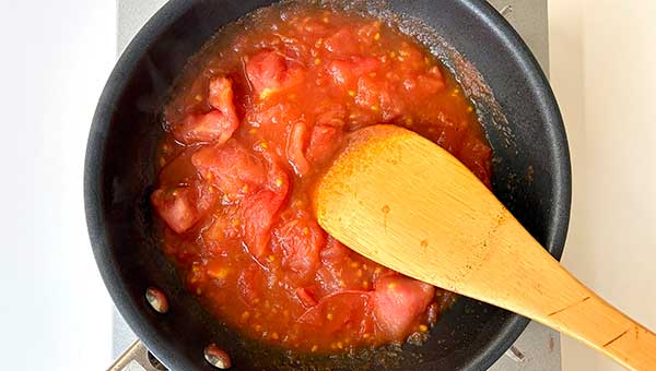 トマトをつぶしながら煮込む トマトをつぶしながら煮込む