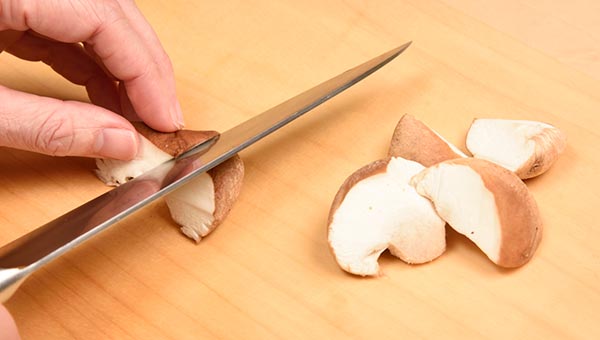 半分に切った椎茸に、斜めに包丁を入れ半分に切る 半分に切った椎茸に、斜めに包丁を入れ半分に切る