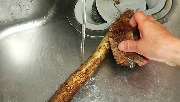 ごぼうを野菜用のたわしやアルミホイルでこすって洗う