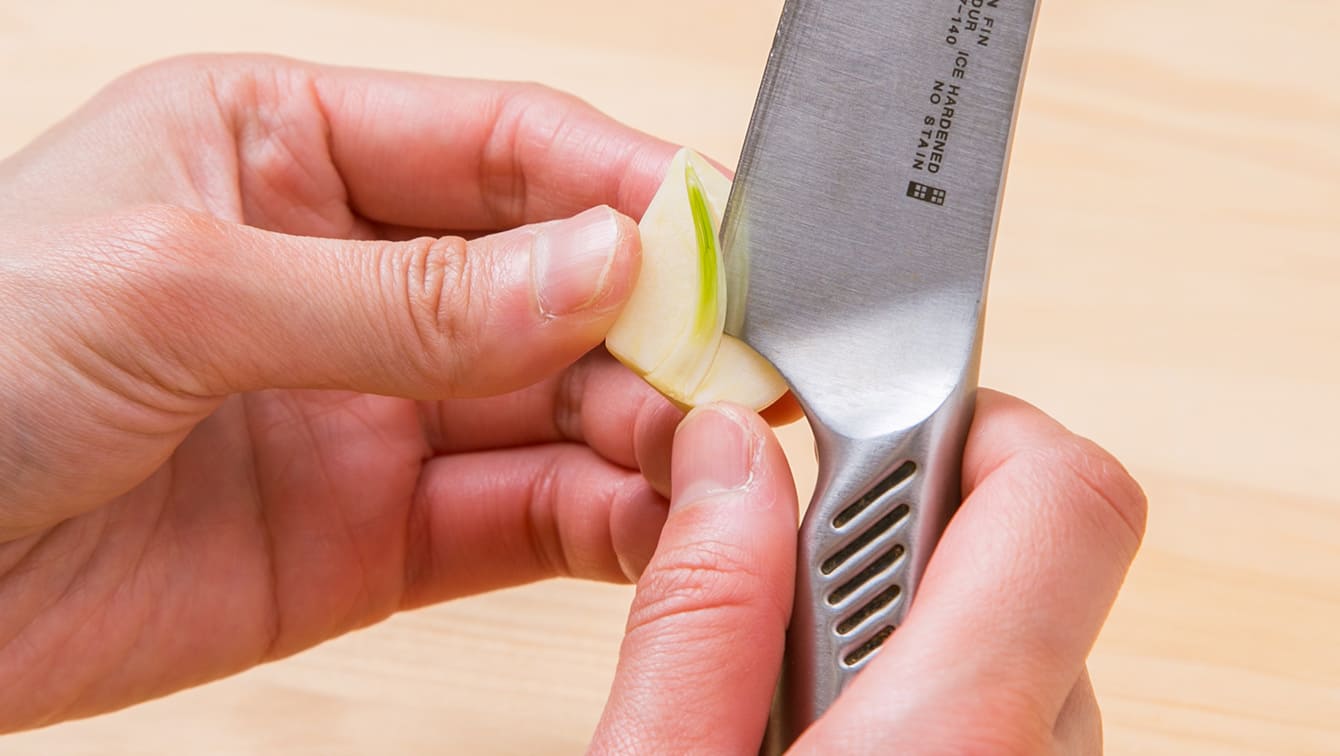 ②ニンニクを縦半分に切り、くさみやえぐみのもとになる芽の部分を取り除く。
